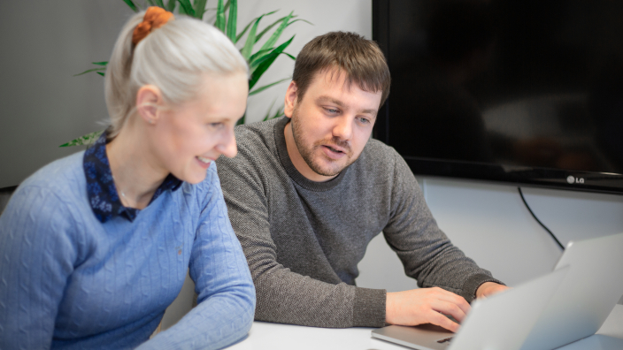 Zwei Personen benutzen die E-Mail-Marketingsoftware LianaMailer auf einem Laptop