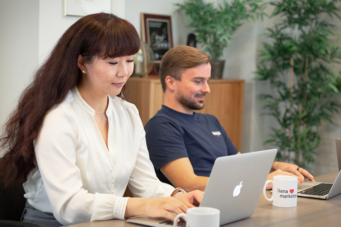 Zwei Personen nutzen die E-Commerce-Lösung LianaCommerce am Laptop