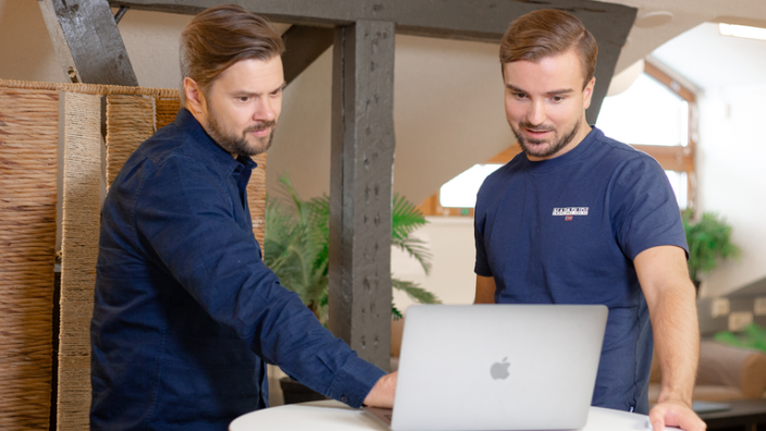 Zwei Personen benutzen die E-Mail-Marketingsoftware LianaMailer auf einem Laptop