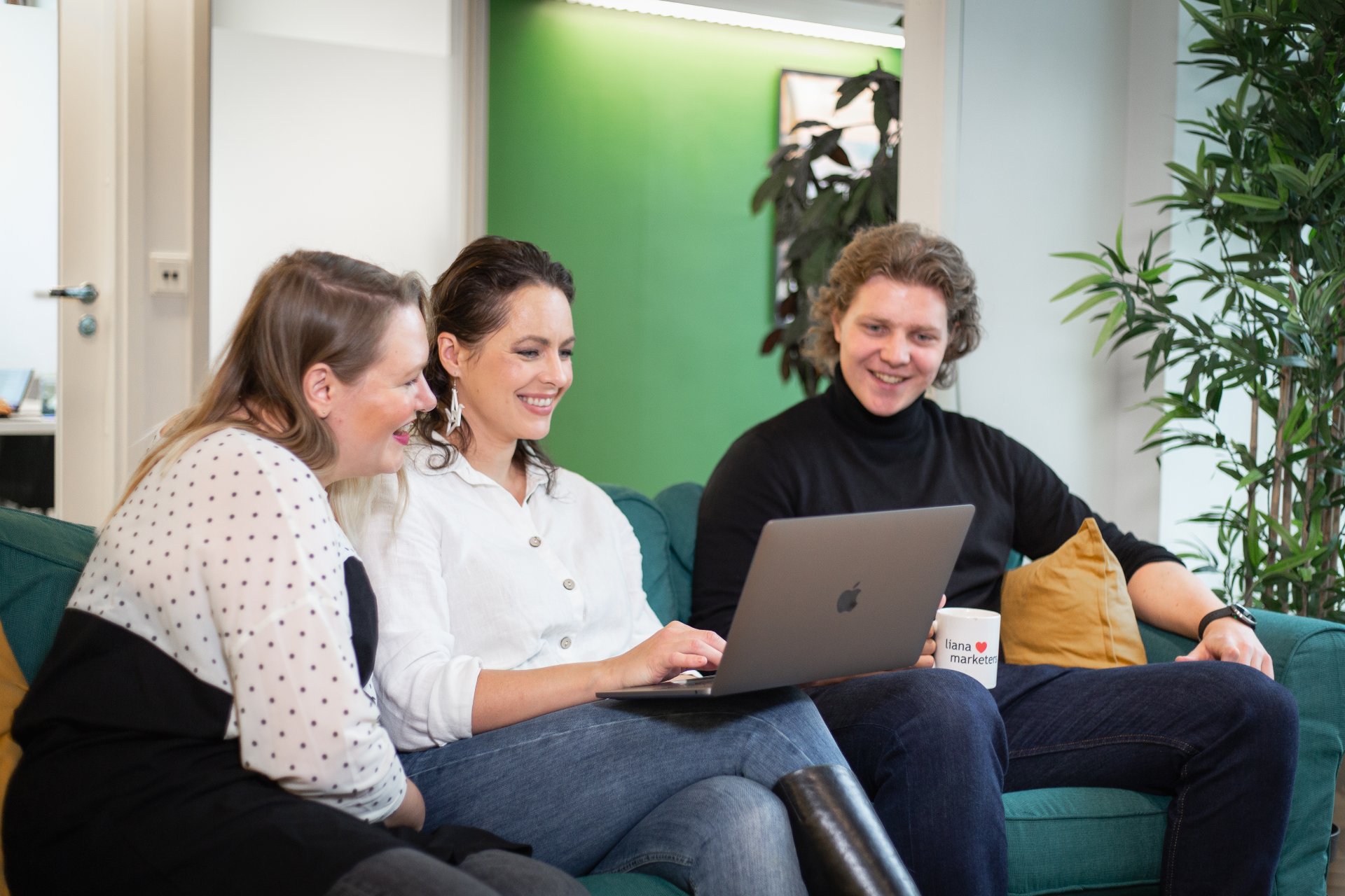 Drei Personen informieren sich über LianaCMS und LianaCommerce am Laptop