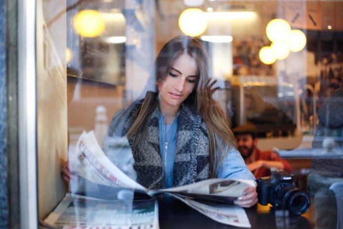 Frau, die Zeitung in einem Restaurant liest